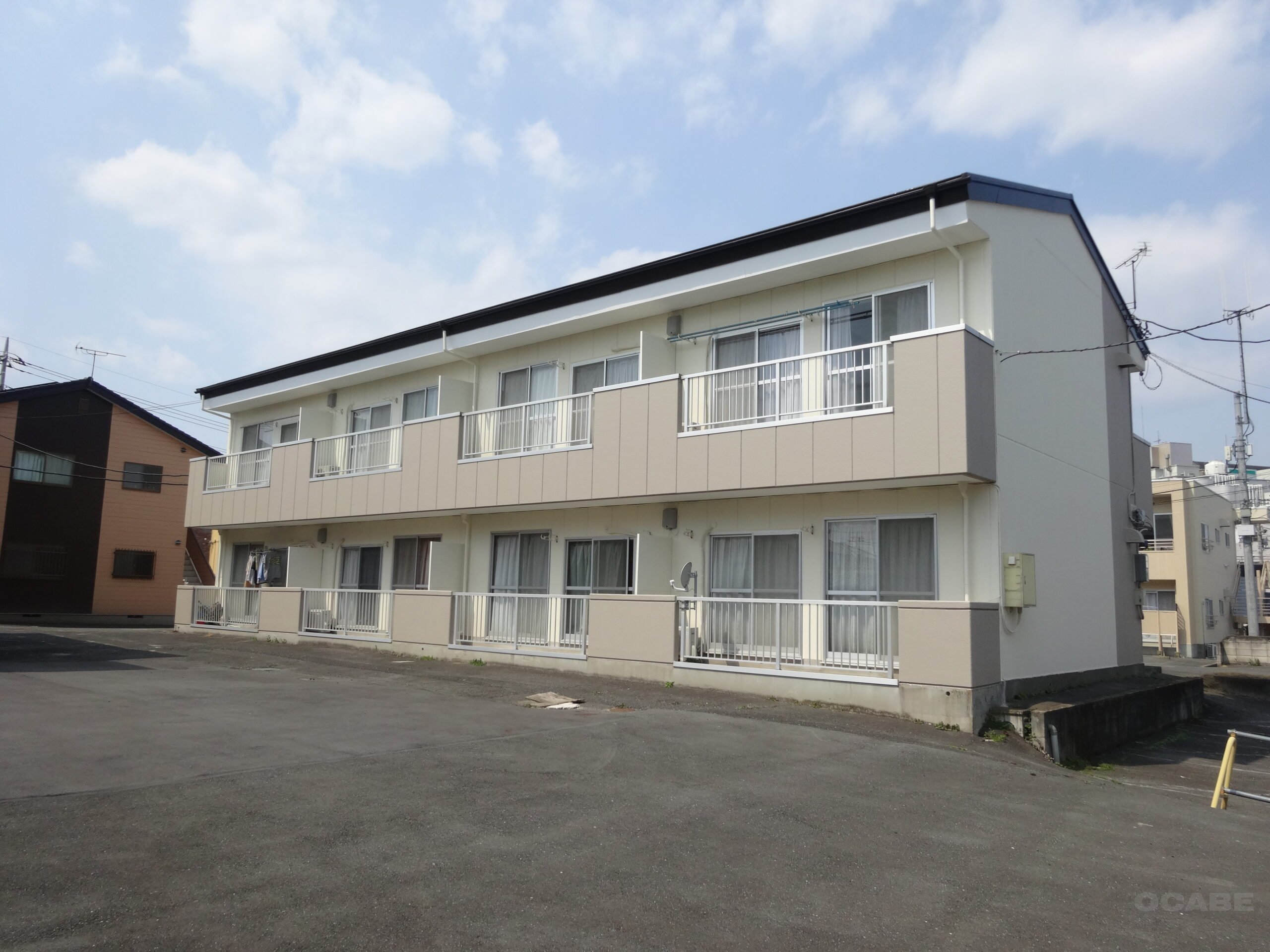 外壁と窓、共用廊下が見える集合住宅の外観